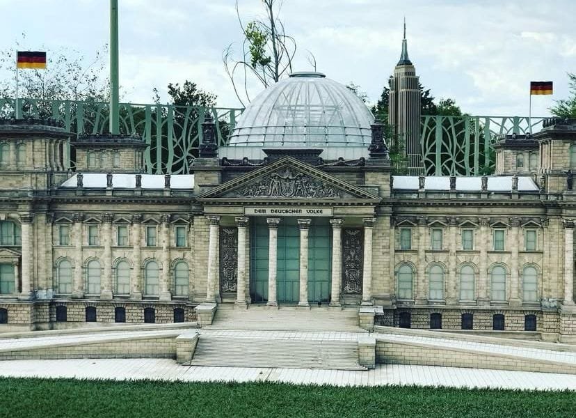 Maqueta a escala de la Sede del Parlamento Alemán (Bundestag), exhibida en el Paseo de los Gigantes en Puebla. A simple vista podemos observar césped y el cielo nublado.