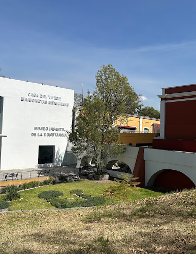 Museo de la constancia con un fondo azul y áreas verdes a su alrededor.